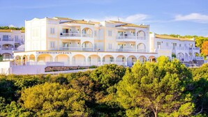 Un hotel de varios pisos con balcones y un bar y restaurante llamado "Kanes".