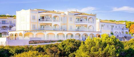 A multi-story hotel with balconies and a bar & restaurant on the ground floor.