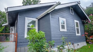 A two-story house with a grey exterior, white trim, and a small front porch.