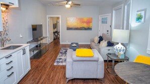 A modern living room with a grey sofa, a small table, and a TV.