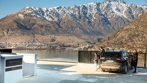 A parking area with a view of a lake and mountains.