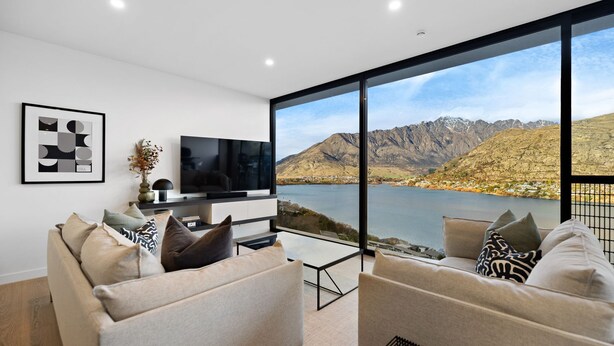 Uma sala de estar moderna com uma janela ampla que oferece uma vista panorâmica das montanhas.
