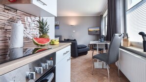 A modern kitchen with a wooden countertop, a built-in oven, and a dining area with a table and chairs.