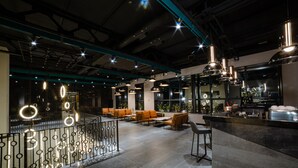 Un área de estar moderna con asientos, bar e iluminación decorativa.