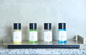 Four bottles of water-based personal care products on a metal shelf. - Kenth Hari Resort Dhaulpur by ShriGo Hotels (Dhaulpur)