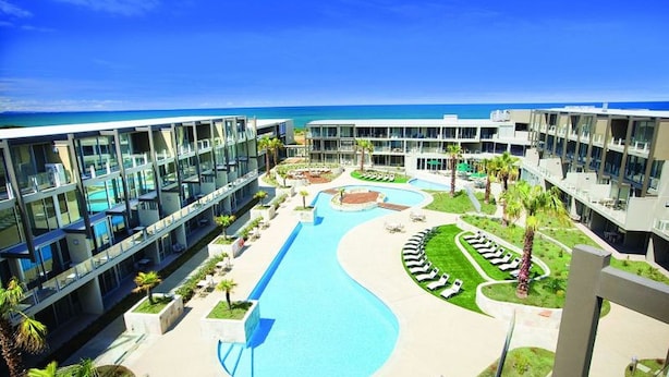 A resort with a swimming pool, lounge areas, and a view of the ocean. - Resort Apartment 224 (TORQUAY)