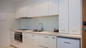 A modern kitchen with white cabinets, a stainless steel sink, and a built-in dishwasher. - Resort Apartment 224 (TORQUAY)