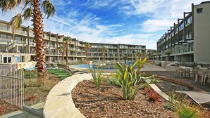 A resort with a pool, palm trees, and a landscaped garden. - Resort Apartment 224 (TORQUAY)