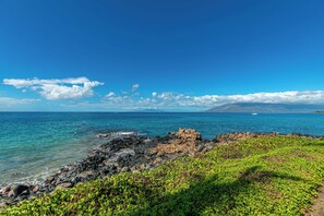 A coastal landscape with rocky terrain and green vegetation. - Royal Mauian #210 Ocean View, Full A/C, Great Location, Close to beaches! (Kihei)