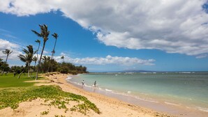 A beach with palm trees, clear water, and a grassy area. - Leinaala Oceanfront #203 Panoramic Ocean View, Renovated, A/C, Great Rates! (Kihei)