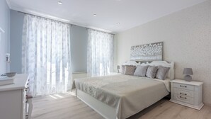 A bedroom with a bed, bedside table, and curtains. - Villa Green Point (Grizane)