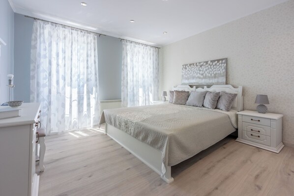 A bedroom with a bed, bedside table, and curtains. - Villa Green Point (Grizane)