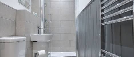 A modern bathroom with a toilet, sink, and shower.