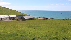 A coastal area with buildings and parked cars near the sea. - Sandpiper Chalet (Bridport)