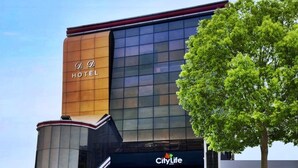 Un hotel con fachada de vidrio moderna y un llamativo logo CityLife.