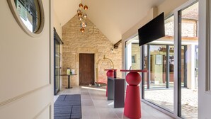 A modern hallway with stone walls, a large window, and a flat-screen TV.