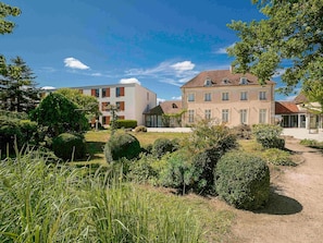 Zona residencial amb edificis moderns, jardins ben cuidats i un cel serè.