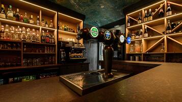 Zona de bar con estanterías llenas de botellas y una estación de grifos.