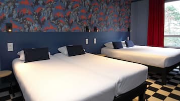 Une chambre d’hôtel avec deux lits, un sol à carreaux et un mur orné d’un motif floral.