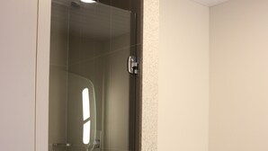 Une salle de bain avec une douche à parois de verre, des toilettes et un lavabo.