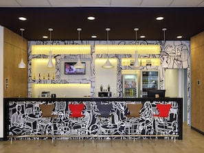 Un espace bar avec un comptoir, des sièges et un écran de télévision.