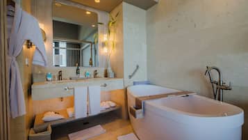 A modern bathroom with a large bathtub, a double sink vanity, and a mirror above the vanity.