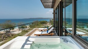 A balcony with a hot tub, lounge chairs, and a view of the ocean. - Sofitel Barú Cartagena (Cartagena)