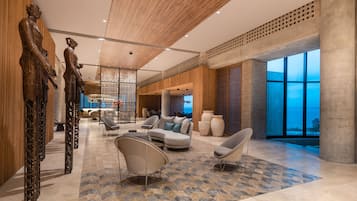 Relax in our spacious lobby with a central seating area, high ceiling, and city views.