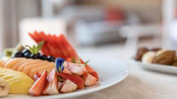 A plate of assorted fruits including melon, strawberries, and bananas.