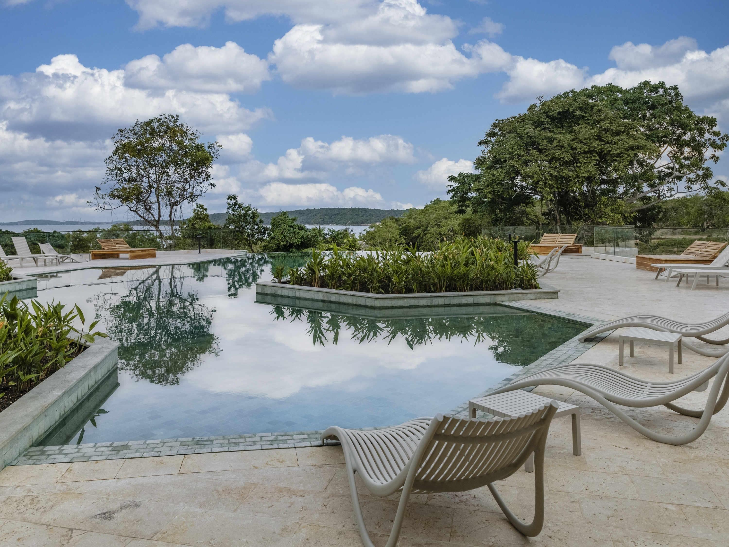 A serene outdoor pool area with lounge chairs and a clear view of the surrounding landscape.