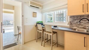 Una cocina moderna con dos taburetes de bar, una ventana con vistas y un lavamanos empotrado.
