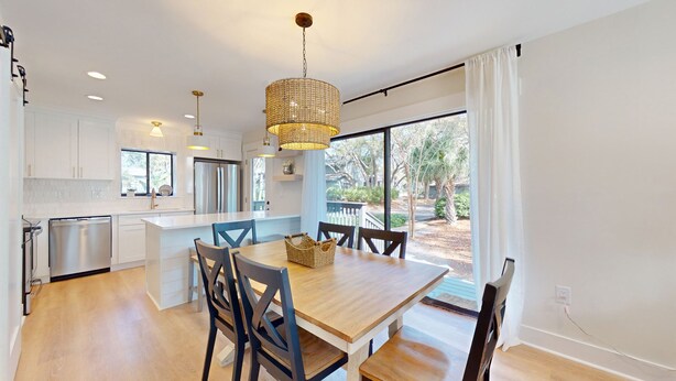 A modern kitchen with white cabinets, stainless steel appliances, and a large island with seating. - Hickory Cove Villa Near Beach, Golf & Pickle Ball at Palmetto Dunes (Hilton Head)