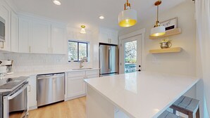 A modern kitchen with white cabinetry, stainless steel appliances, and pendant lighting. - Hickory Cove Villa Near Beach, Golf & Pickle Ball at Palmetto Dunes (Hilton Head)