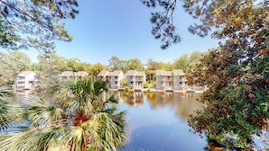A row of beachfront condos with a view of the water and palm trees. - Hickory Cove Villa Near Beach, Golf & Pickle Ball at Palmetto Dunes (Hilton Head)