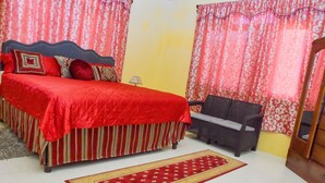 Une chambre à coucher avec un lit, un canapé, un tapis et des rideaux.