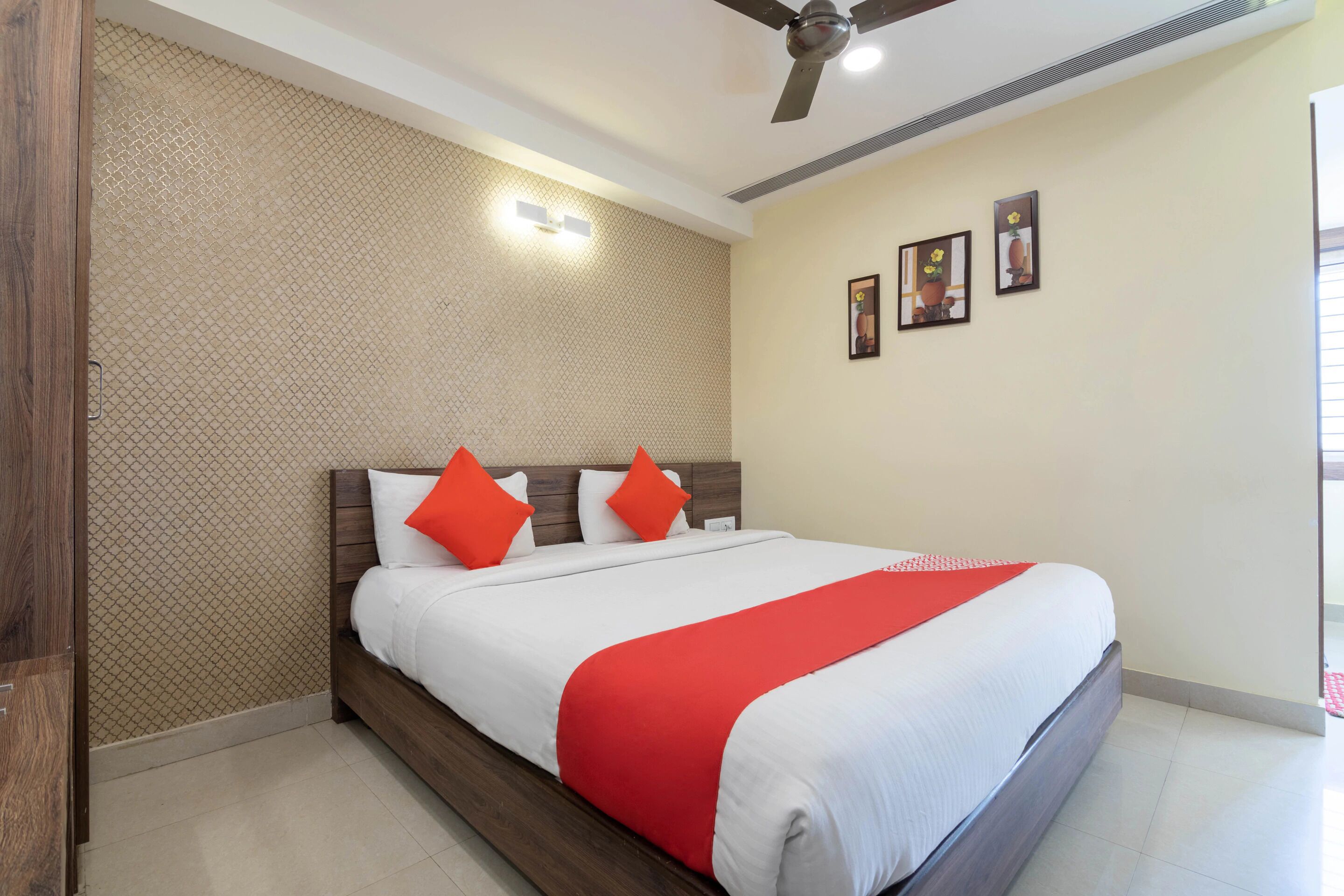 Una habitación de hotel con una cama, un ventilador de techo y una pared con textura.