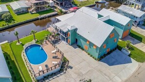Una propiedad residencial con piscina, muelle y canal.