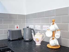 Une cuisine équipée d’un grille-pain, d’une bouilloire et d’un porte-tasses.