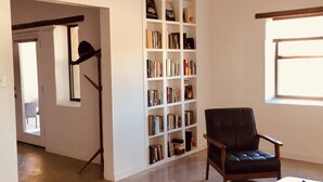 A living room with a bookshelf, a leather armchair, and a coffee table.