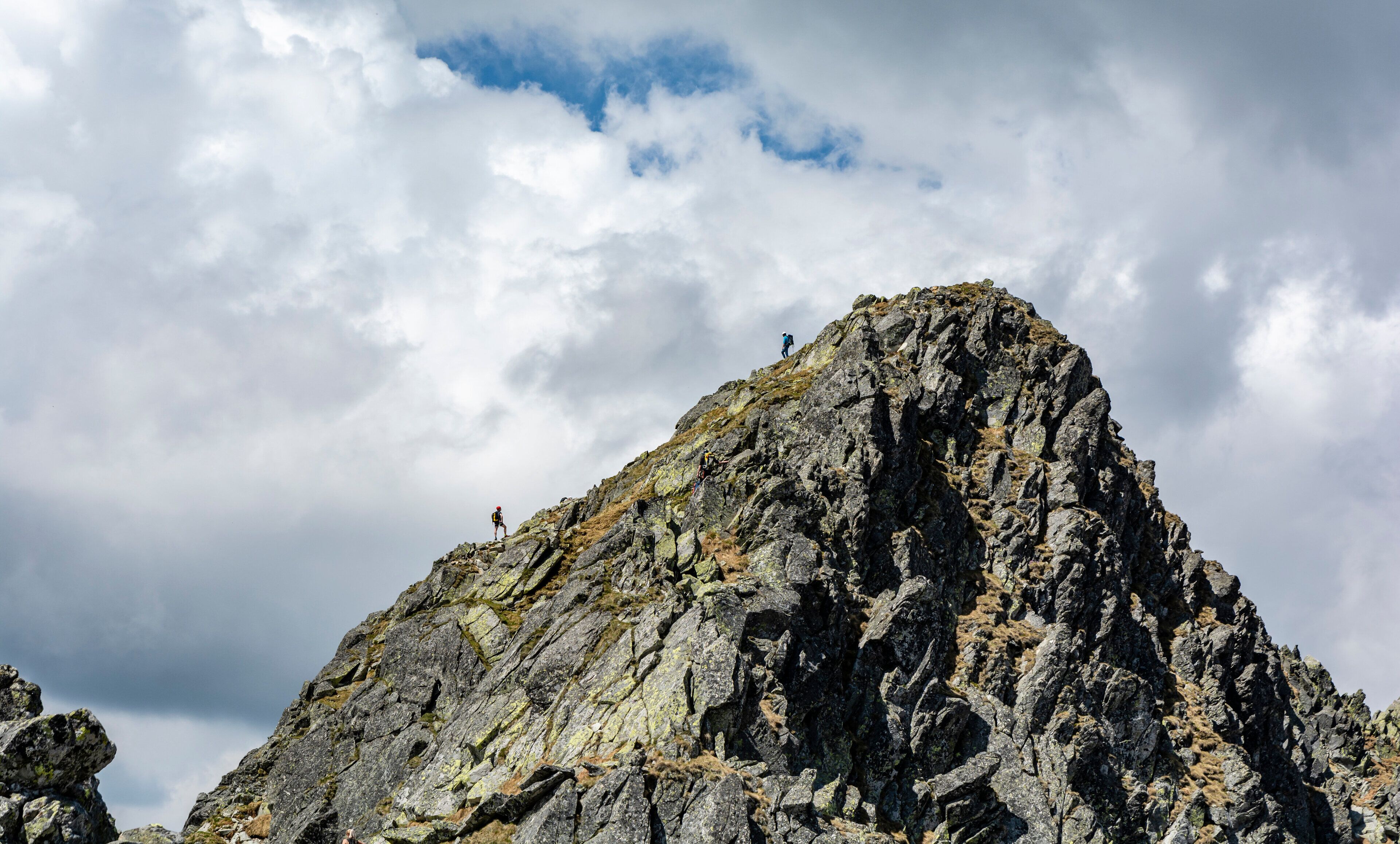 A rugged mountain peak with rocky terrain and sparse vegetation.