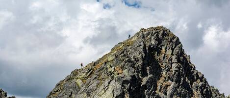 A rugged mountain peak with rocky terrain and sparse vegetation.