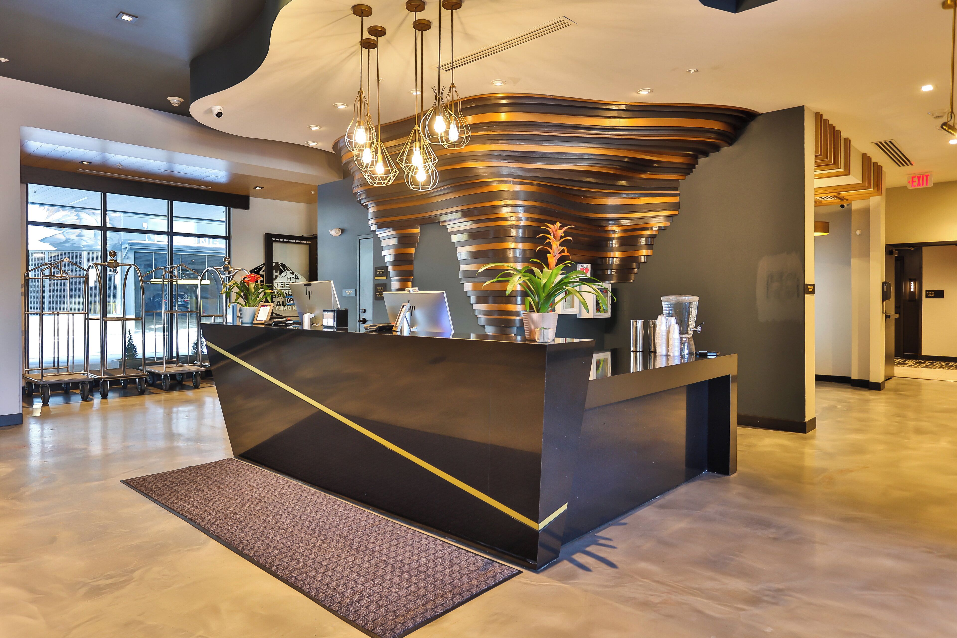 A modern reception desk with a unique curved design, a large window offering a view of the outside, and a clean, polished floor.
