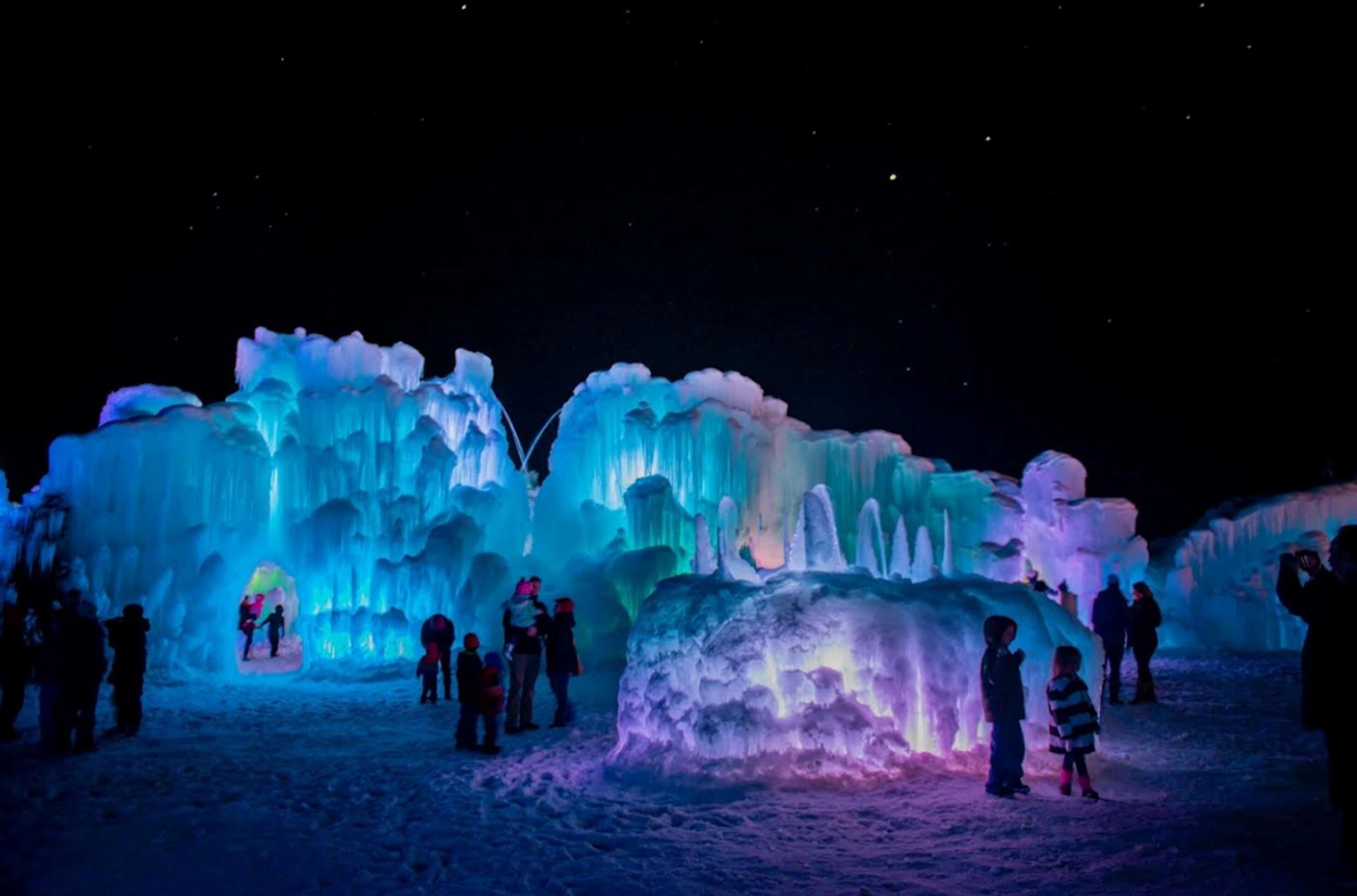 An ice sculpture with people around it.
