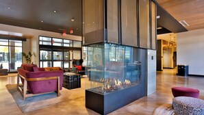 En moderne lobby med en glaspejs, behagelige siddepladser og store vinduer.