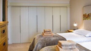 A bedroom with a bed, a bedside table with a lamp, a wardrobe, and a dresser. - 3 bedroom accommodation in Linlithgow, near Edinburgh (Linlithgow, near Edinburgh)