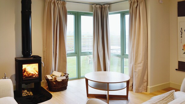 A cozy living room with a wood-burning stove, a round table, and a sofa. - 3 bedroom accommodation in Linlithgow, near Edinburgh (Linlithgow, near Edinburgh)