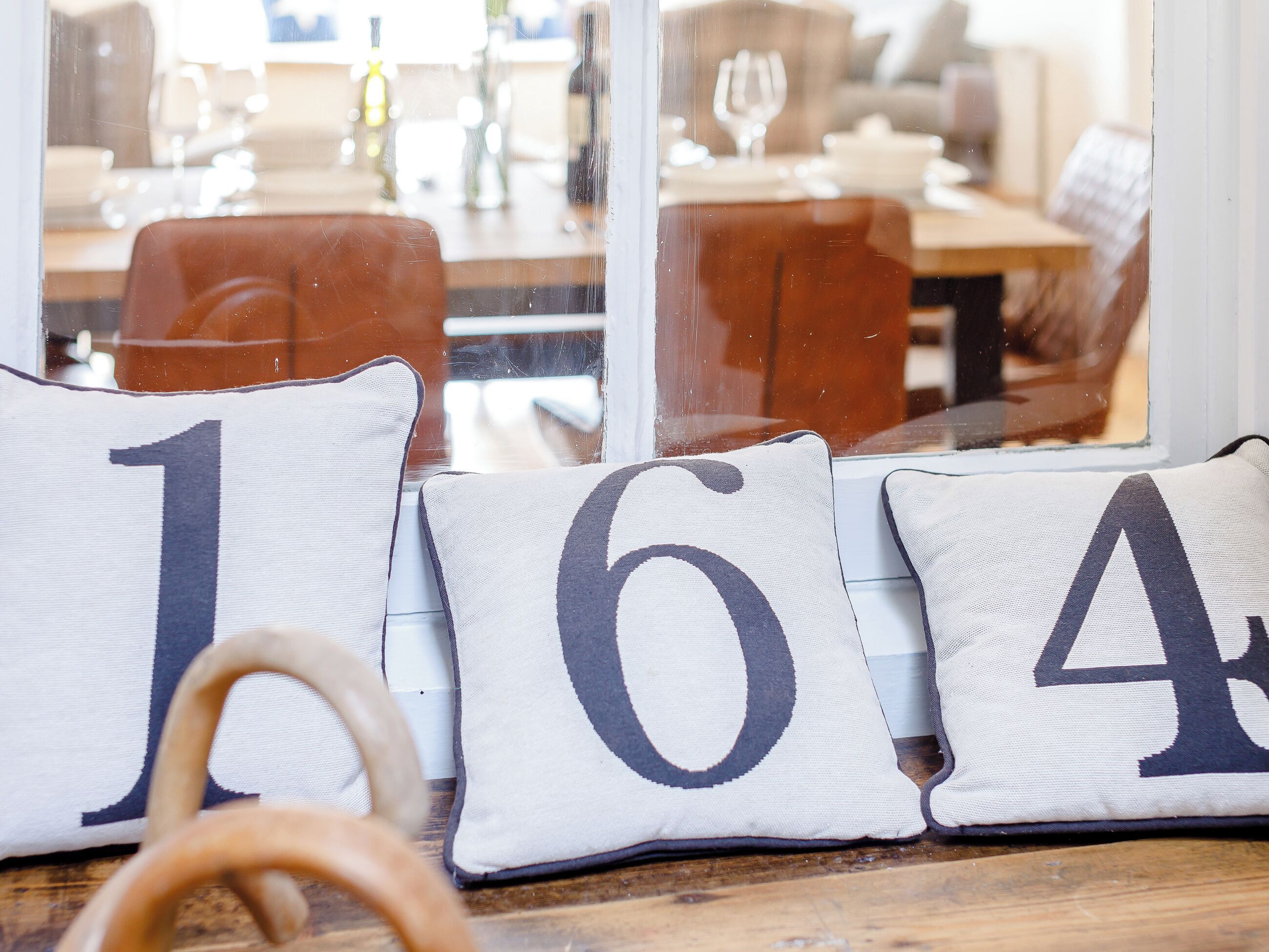 A wooden table with three cushions marked with numbers 1, 6, and 4.