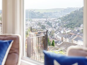 A view from a window overlooking a town with buildings and greenery.