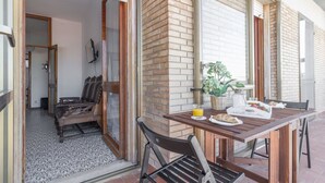 Un comedor con una mesa lista para dos, un banco y una planta en maceta.