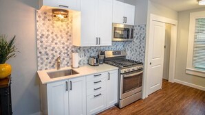 Una cocina moderna con armarios blancos, electrodomésticos de acero inoxidable y un salpicadero decorado.